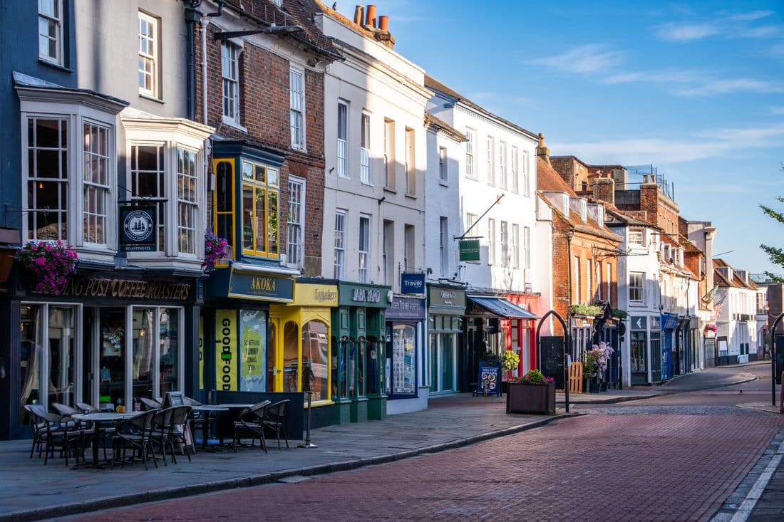 Colourful shopfronts along a British high street in early morning sunshine